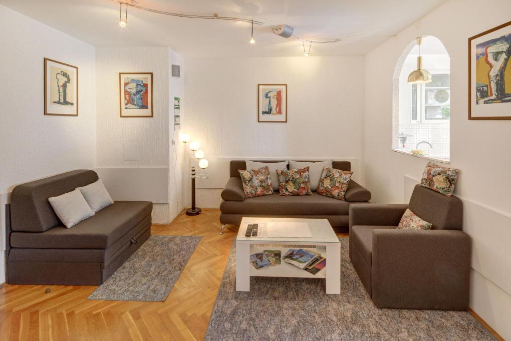 Sala de estar con 2 sofás y mesa de centro en Apartman Osijek, en Osijek