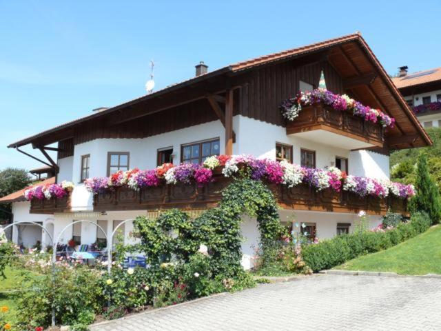 un edificio con flores a un lado. en Ferienwohnungen Kasparbauer, en Regen