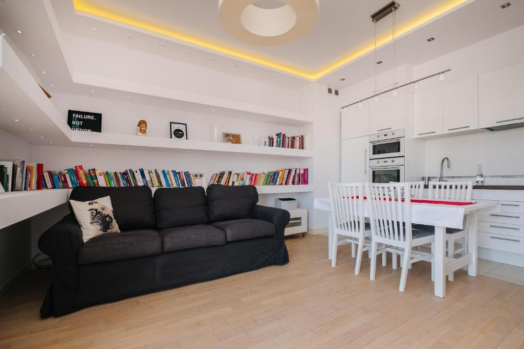 a living room with a couch and a table and a kitchen at Modern Apartment Across the Ponds in Warsaw