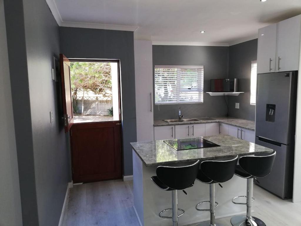 a kitchen with a counter and two bar stools at Milo's Sky Grey Guest House - No Load shedding in Cape Town