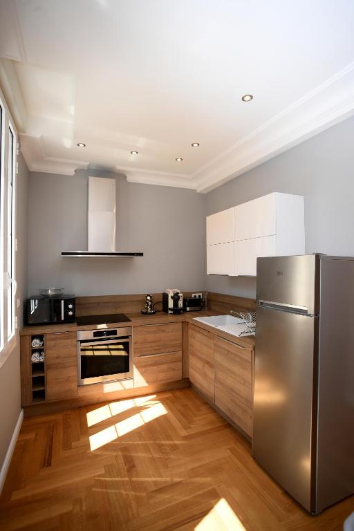 une cuisine avec un réfrigérateur en acier inoxydable et du parquet dans l'établissement Libourne Hyper Centre à deux pas de Saint Emilion, à Libourne