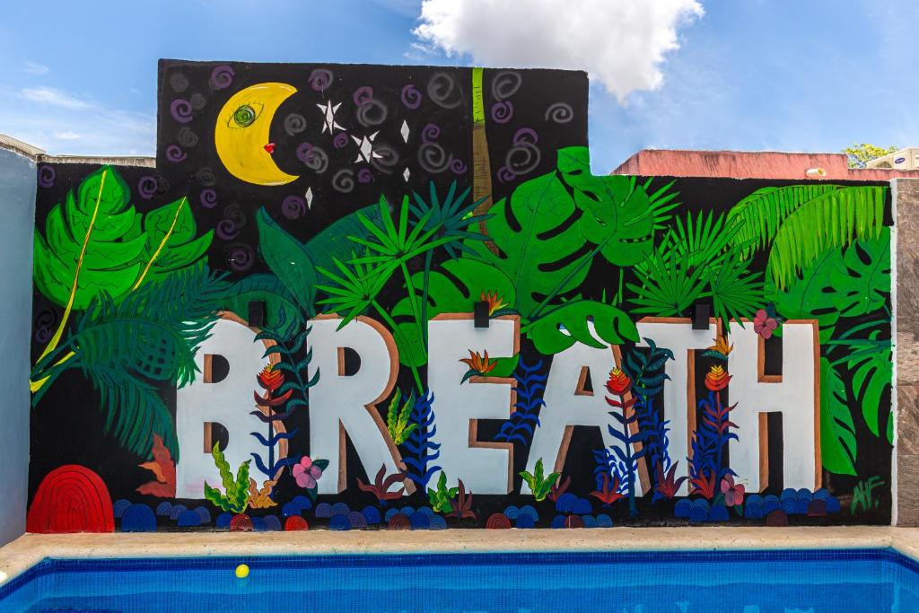 een muur met een bordje waarop 'brullen' staat naast een zwembad bij Santa Fe Studios And Suites in Cancun