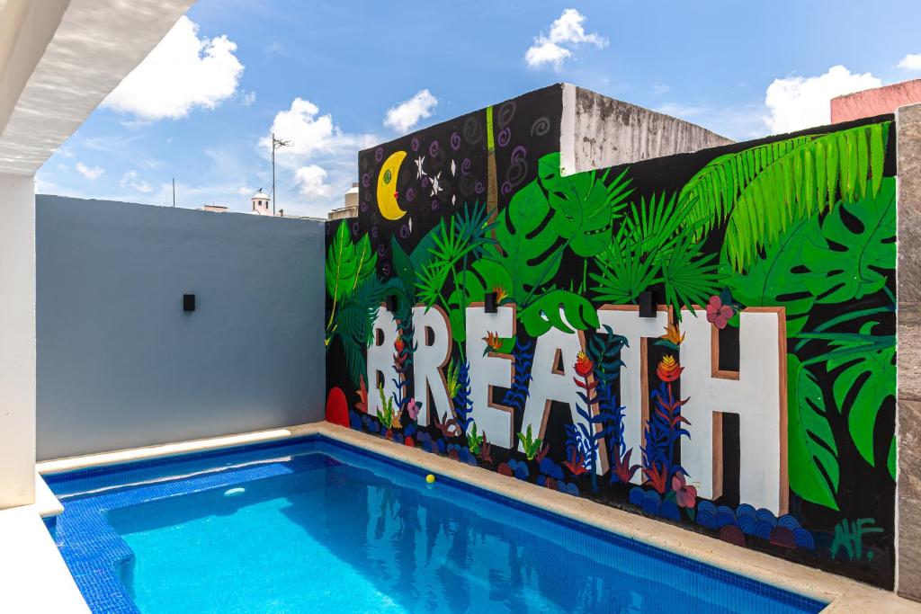 un mural en el lateral de un edificio con piscina en Santa Fe Studios And Suites en Cancún
