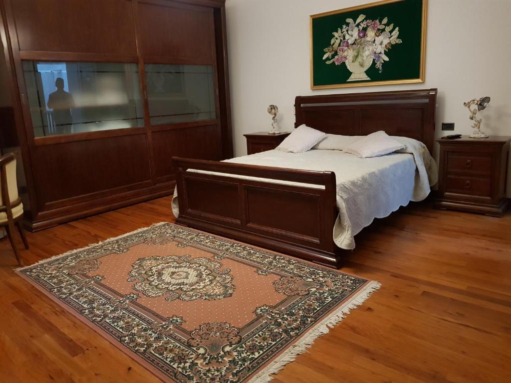 una camera con un grande letto e un tappeto di B&B Tenuta Madiba a Ravenna