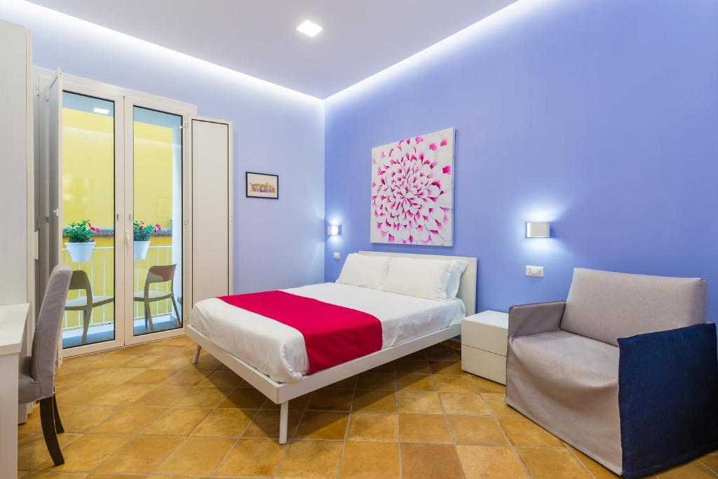 - une chambre bleue avec un lit et une chaise dans l'établissement Fuoro 10 Sorrento, à Sorrente