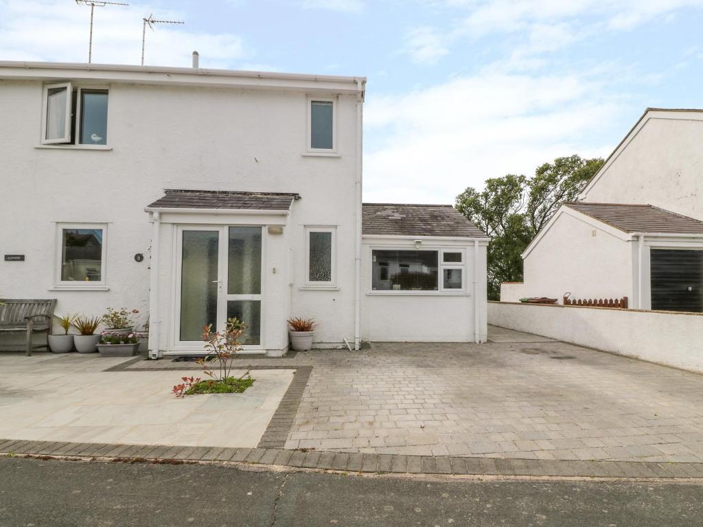 a white house with a large driveway at Lliwedd in Pwllheli