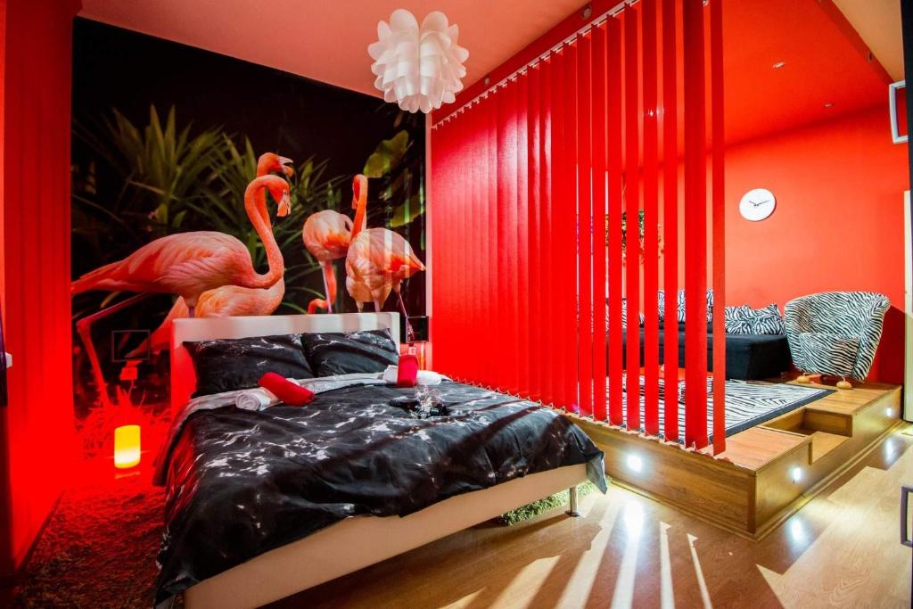a red bedroom with a bed with flamingos in it at FLAMINGOS Apartman & Fitness OSIJEK - blizina Bolnice KBC Osijek in Osijek