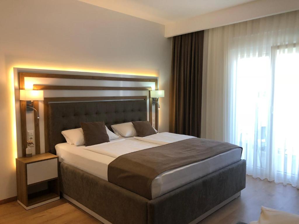 a bedroom with a large bed and a large window at Hotel Rheinbrücke in Rheinfelden