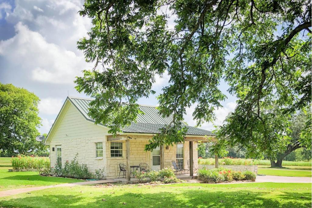 a house with a green lawn and trees at Inn at Indian Creek in Burton