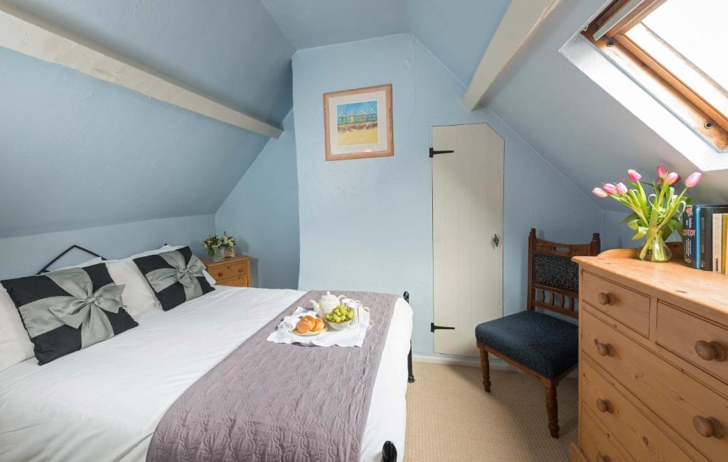 a bedroom with a bed with a table and a chair at Cobbles House in Whitby
