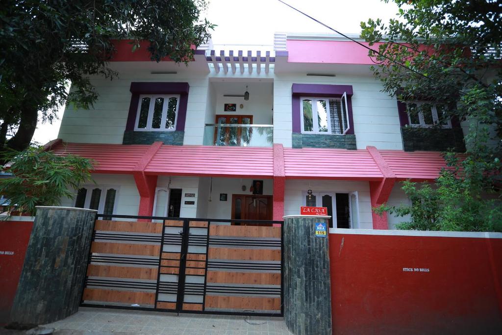 a house with a red fence in front of it at LA CASA THE HOMESTAY in Trivandrum