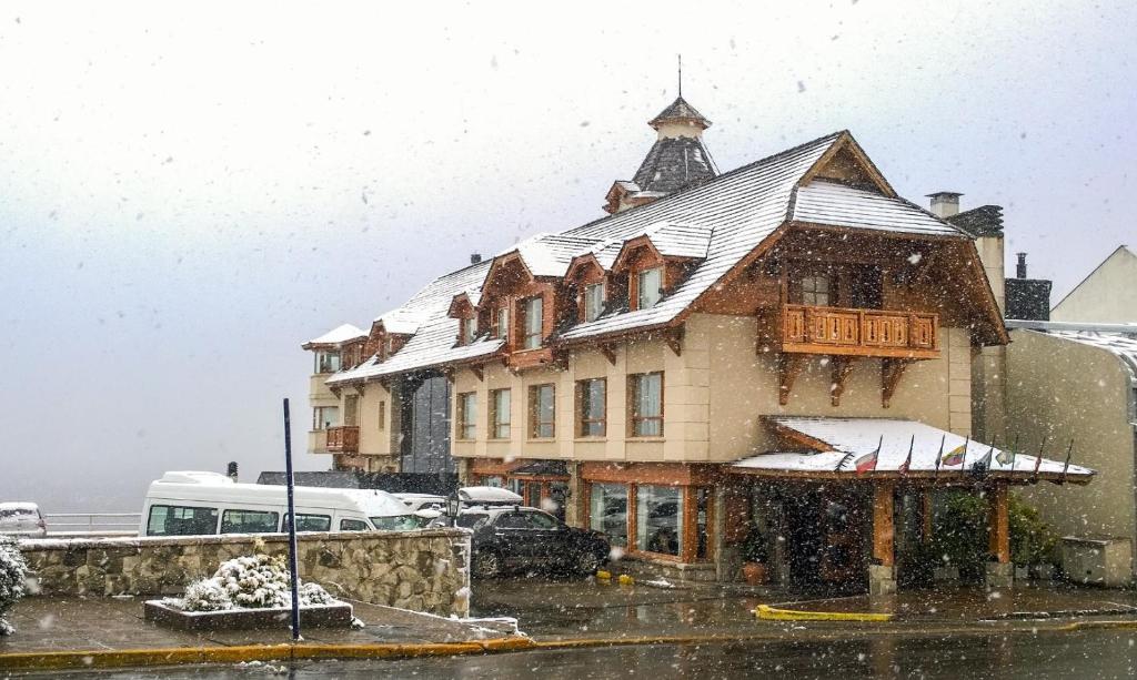 boats are docked at a dock in front of a building at Cacique Inacayal Lake Hotel & Spa in San Carlos de Bariloche