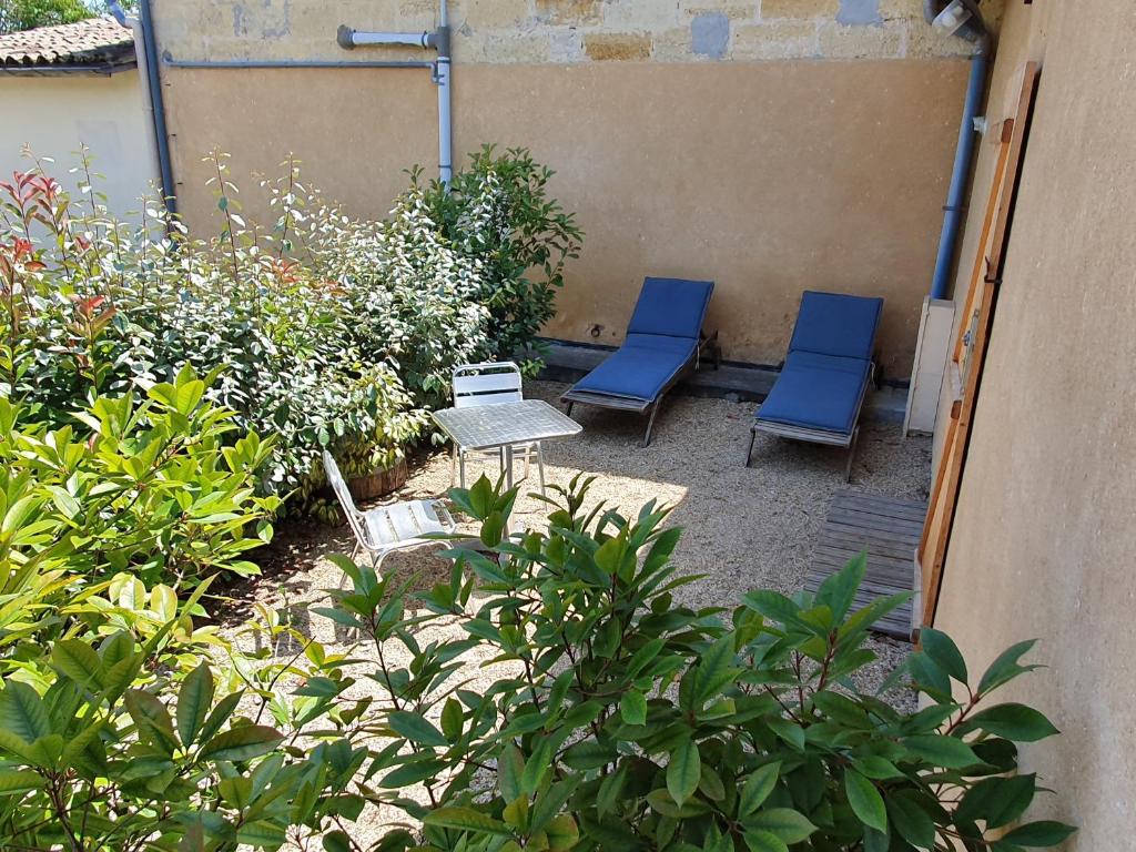 2 blaue Stühle und ein Tisch im Garten in der Unterkunft Gite Brandet in Savignac-sur-lʼIsle