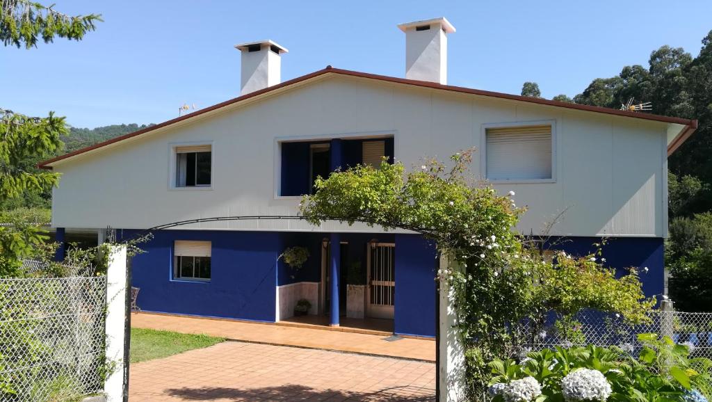 una casa blanca y azul con una valla en Casa Azul Beluso, en Bueu