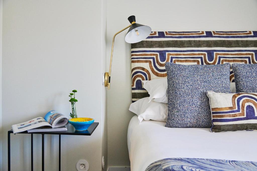 リスボンにあるLisbon Best Choice Apartments Alfamaのベッドルーム1室(ランプと本付きのベッド1台付)