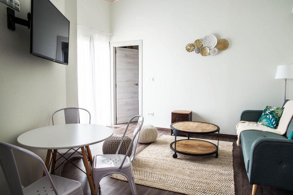 een woonkamer met een bank en een tafel en stoelen bij Apartamentos Estela de Altamira in Santillana del Mar