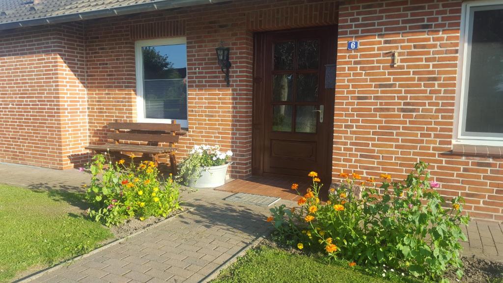 a brick house with a wooden door and a bench at Ferienhaus Ahlers in Pronstorf