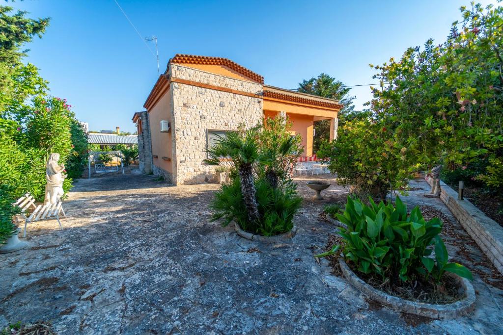 une maison avec deux arbres devant elle dans l'établissement Villa Benny a Due passi dal mare, à Santa Caterina
