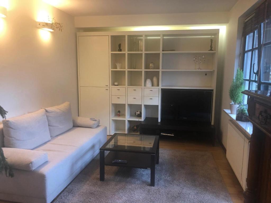 uma sala de estar com um sofá e uma mesa de centro em Apartament Odkryta 36a em Varsóvia