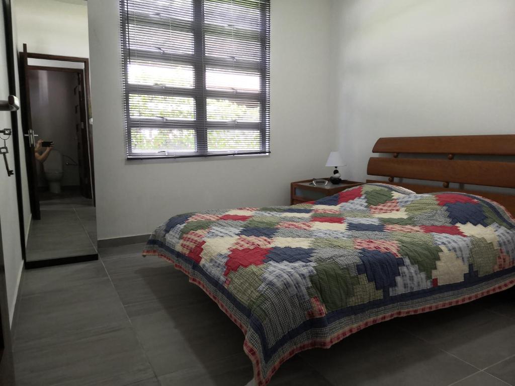 um quarto com uma cama com uma colcha em Bij BRAKKE em Paramaribo