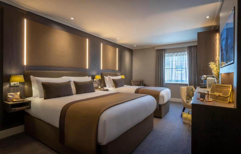 a hotel room with two beds and a window at Belvedere Hotel Parnell Square in Dublin