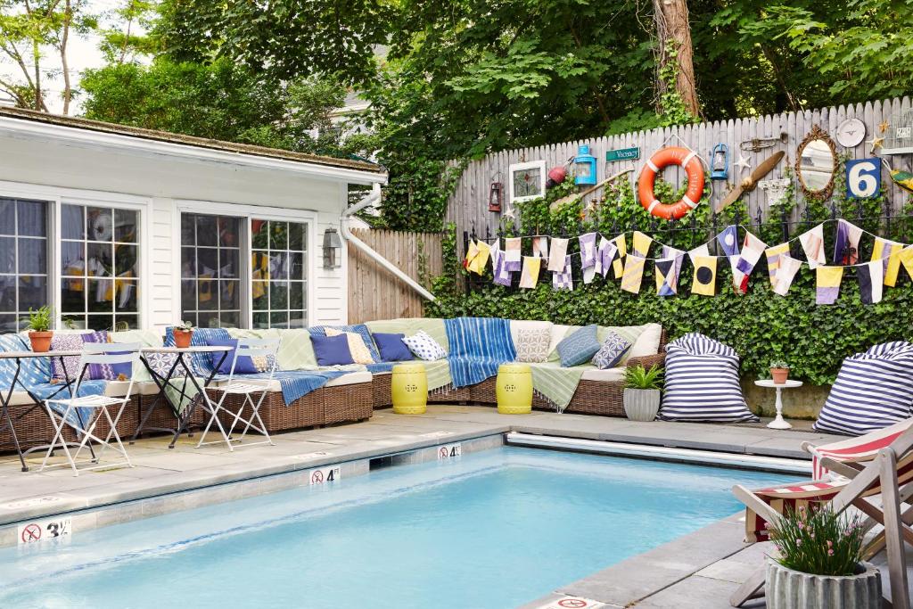 a pool with a couch and chairs next to a house at Eben House in Provincetown