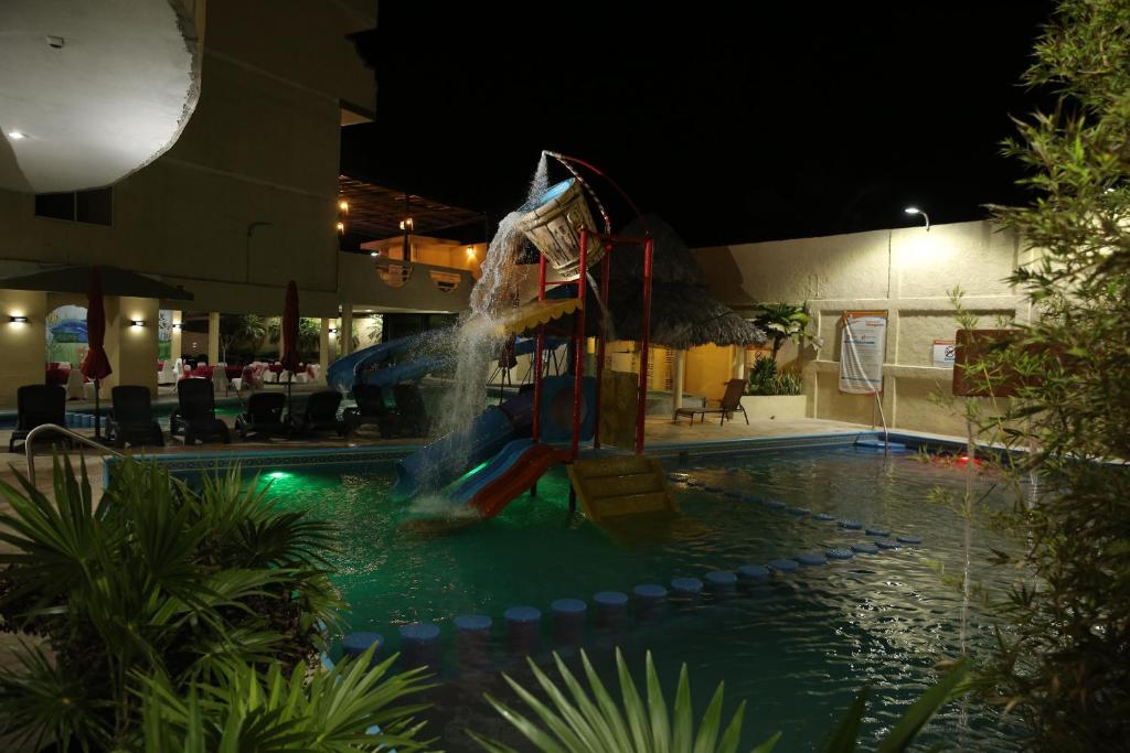 un tobogán de agua en una piscina por la noche en Hotel Miramar Inn, en Ciudad Madero