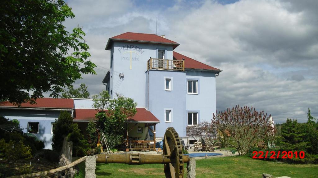 a white building with a clock tower on top of it at penzion Poutník in Mláka