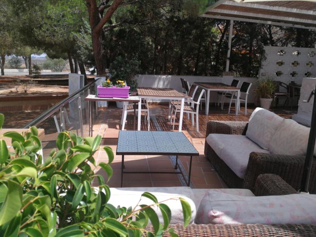 a patio with a couch and tables and chairs at Hotel Marisma Sancti Petri in Chiclana de la Frontera