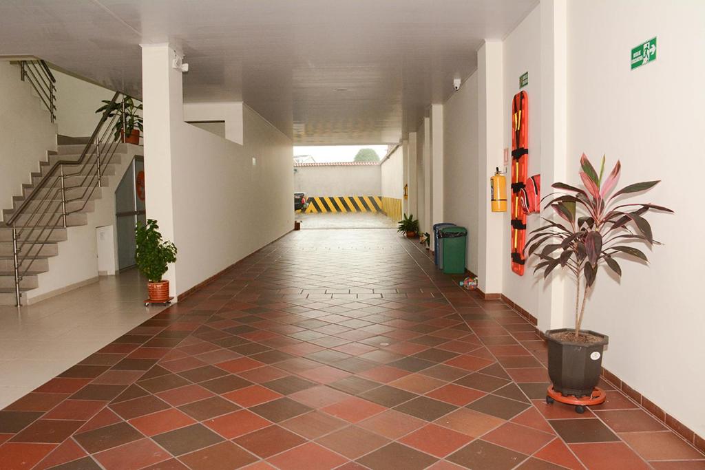 an empty hallway with a potted plant and stairs at Hotel Villareal del Llano in Villavicencio