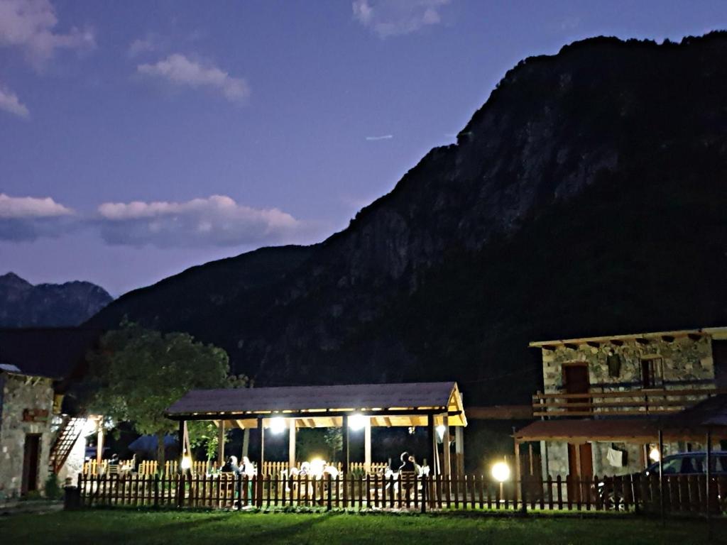 un edificio con una recinzione di fronte a una montagna di Guest House Flodisa a Theth