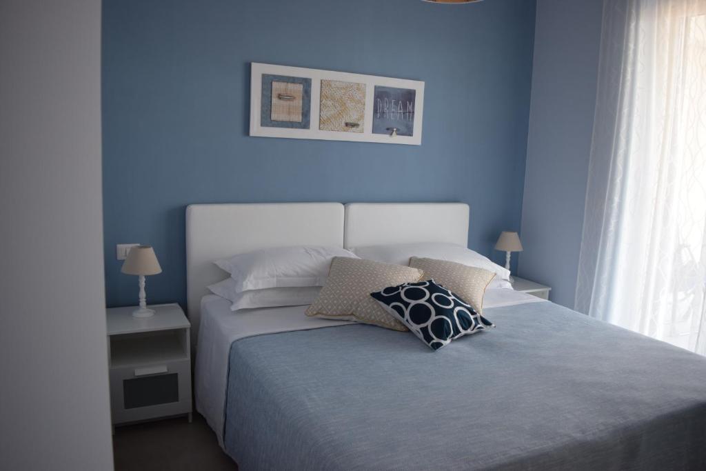 a bedroom with blue walls and a bed with pillows at Casa Vacanze Lombardo in Santa Teresa di Riva