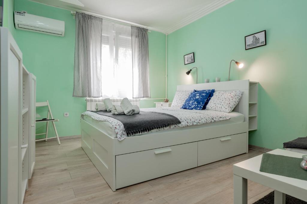 a bedroom with a bed with blue and green walls at Apartman Gloria 2 in Belgrade