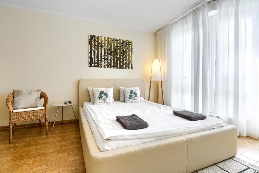 シュチェチンにあるApartament Gajaのベッドルーム(大きな白いベッド1台、椅子付)