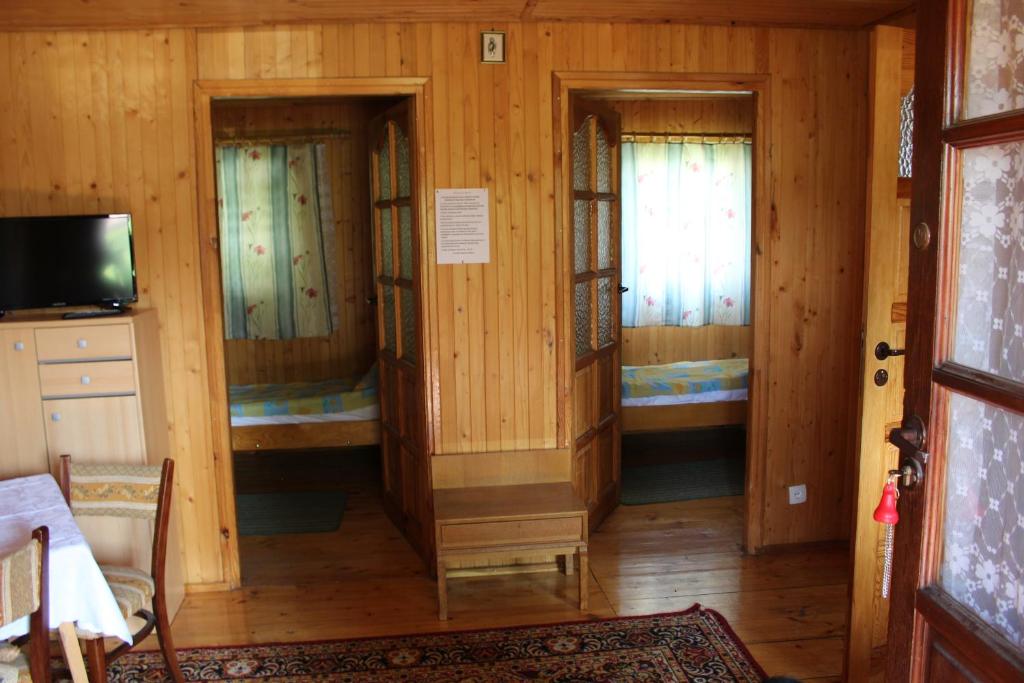 a room with three windows in a wooden house at Domki " ELRINO " in Jastarnia