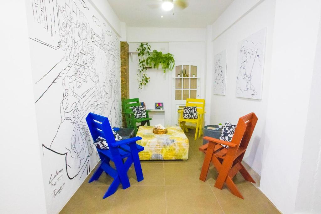 a room with chairs and drawings on the wall at Whostal in Santiago de los Caballeros