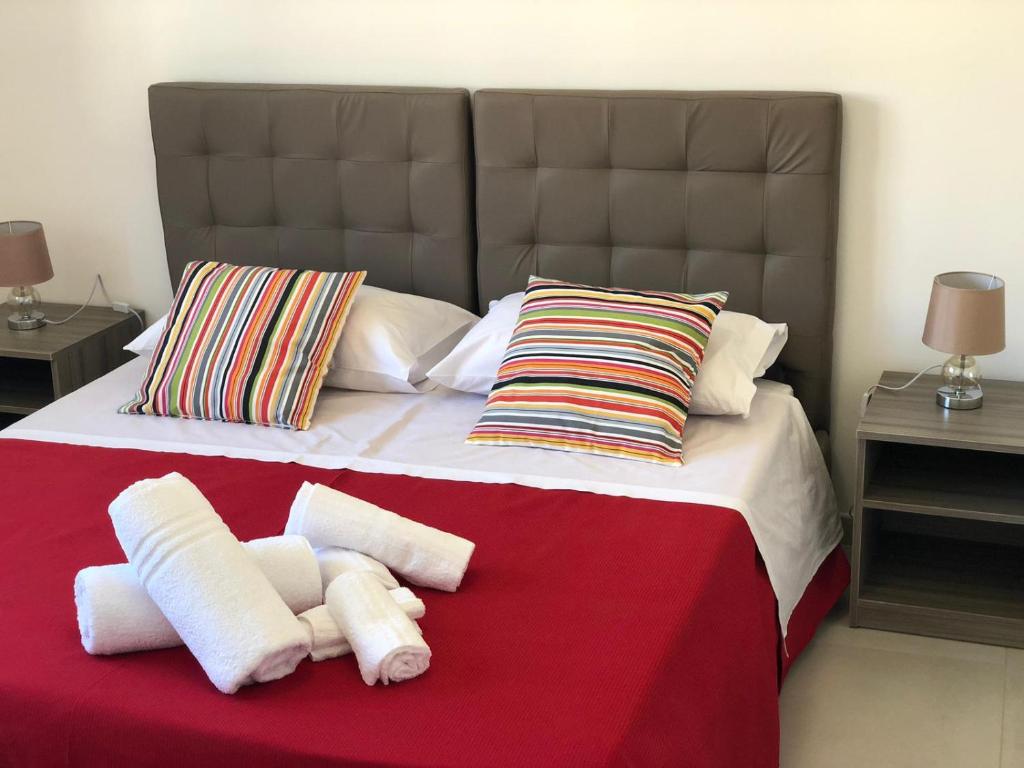 une chambre avec un grand lit avec des serviettes dessus dans l'établissement 3G BAROQUE APARTMENTS, à Lecce