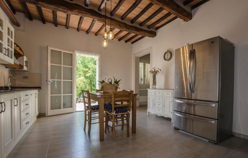 a kitchen with a table and a stainless steel refrigerator at Poggio al Sole in Montespertoli