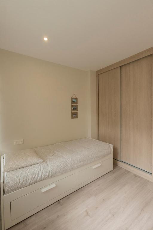 A bed or beds in a room at Noray Apartamentos Viveiro