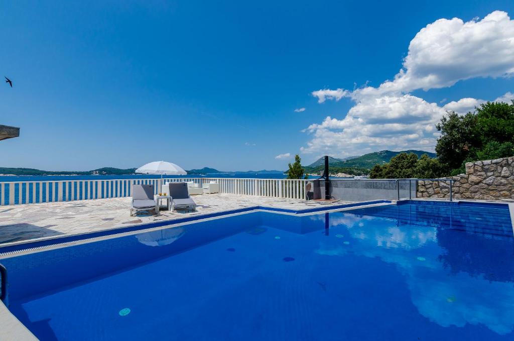 una piscina con 2 sillas y una valla en Stone Apartments, en Dubrovnik