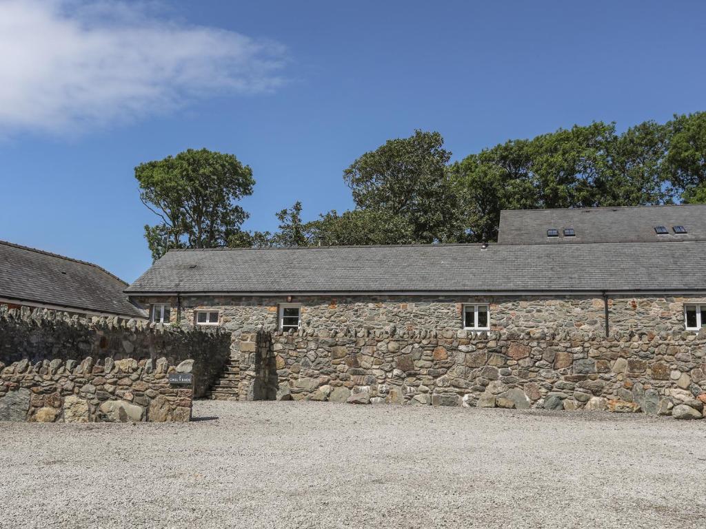 an old stone building with a stone wall at Gwel y Rhos in Llanfairpwllgwyngyll