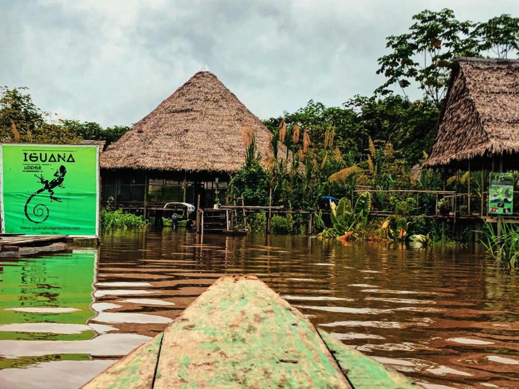 ein Boot in einem Wasserkörper mit einem Schild in der Unterkunft Iguana Lodge Perú in Iquitos