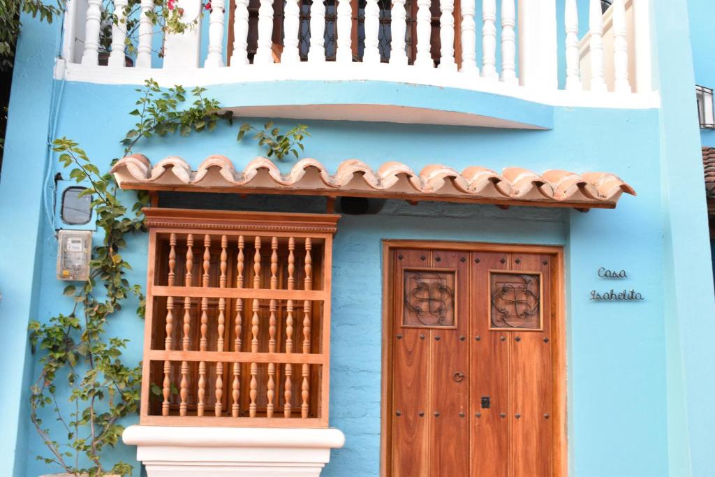 Casa azul con puerta de madera y balcón en Casa Isabelita en Mompox