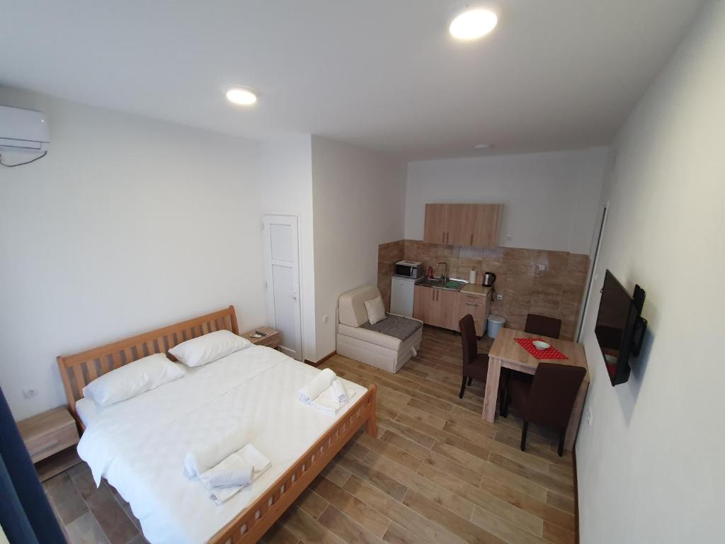 ein kleines Schlafzimmer mit einem Bett und einer Küche in der Unterkunft Apartmani Stari Most in Trebinje