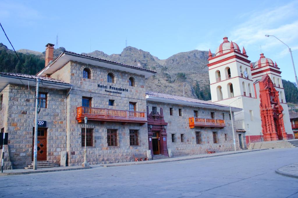 ein altes Gebäude an der Seite einer Straße mit zwei Türmen in der Unterkunft Hotel Presidente Huancavelica - Asociado Casa Andina in Huancavelica
