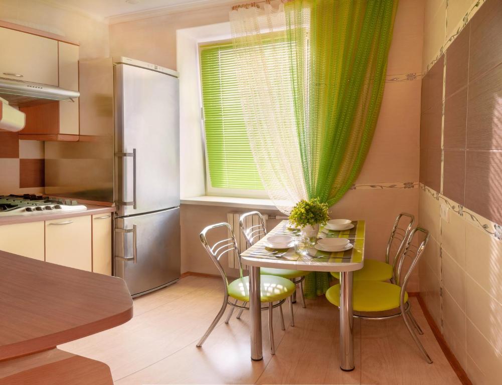 ポルタヴァにあるLuxury 3 Rooms Apartments in Center by Green Houseのキッチン(テーブル、椅子付)、窓