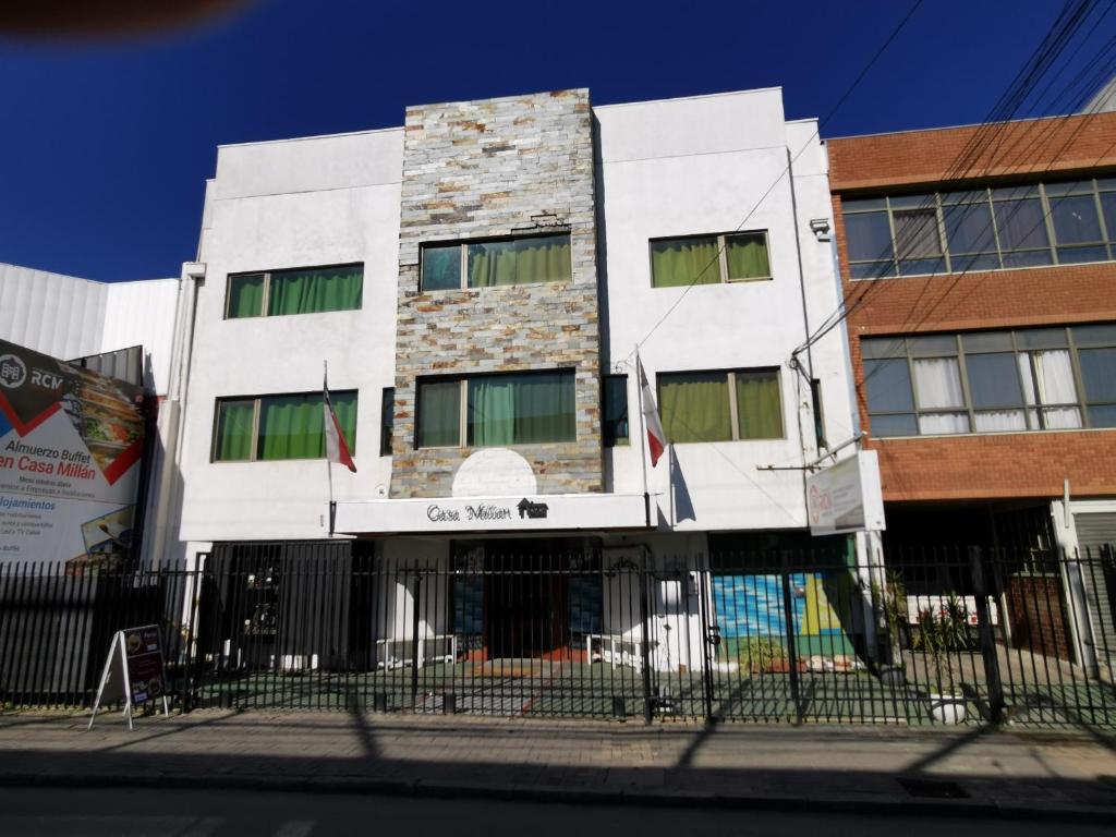un edificio blanco con una valla delante en Residencial la Casa de Millan en Rancagua