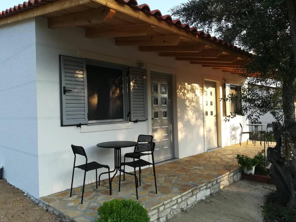 a patio with chairs and a table in front of a house at Janakis Garden Livadi Beach in (( Spile ))