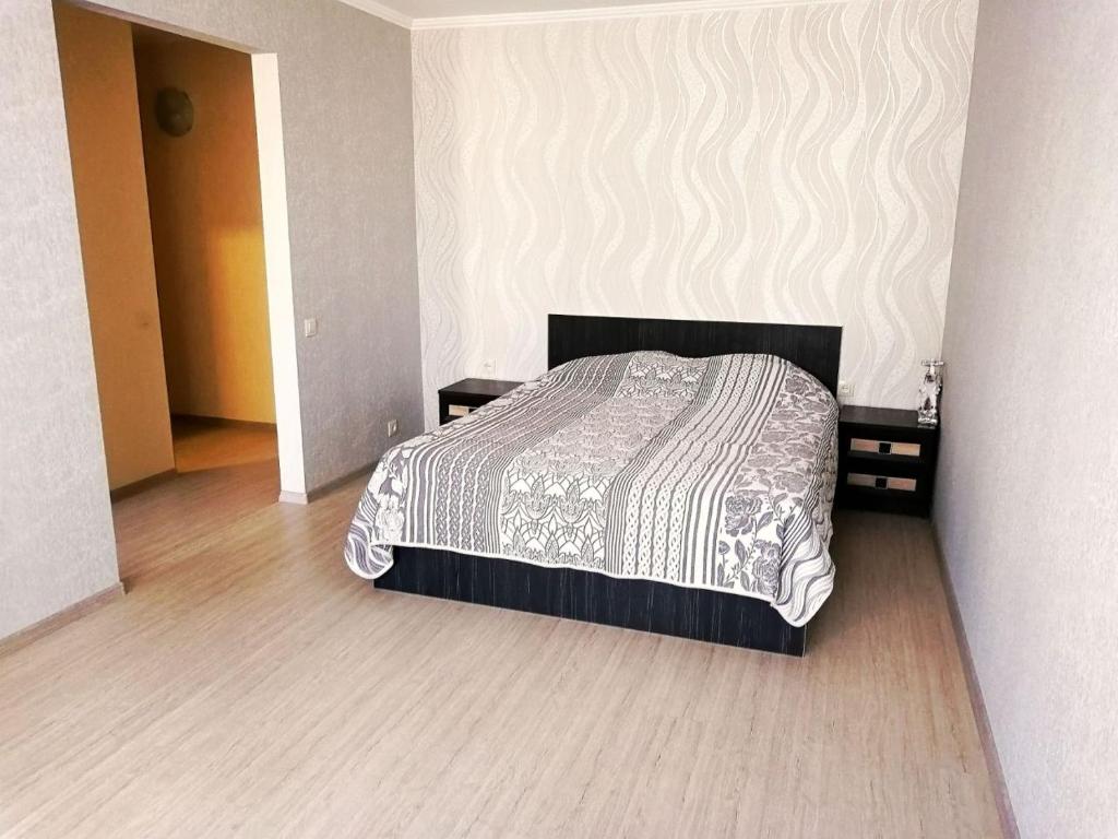 a bedroom with a bed and two night stands at Апартаменты на Ивана и Юрия Лип in Odesa