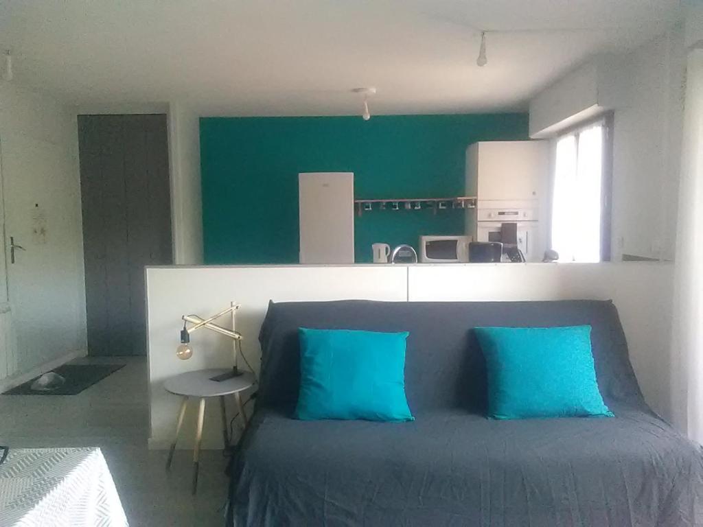 1 dormitorio con 2 almohadas azules en 1 Passage du Château, en Rumilly